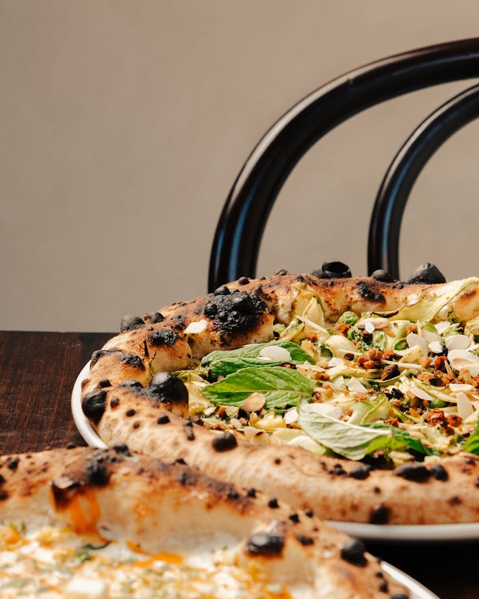 Tantalizing artisan pizzas served on a rustic wooden table, showcasing fresh toppings and charred crusts.